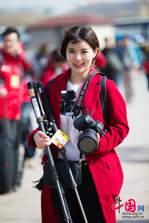 2016年兩會，人民大會大堂前，一位笑容燦爛的紅衣女記者正步入大會堂。中國網(wǎng) 鄭亮 攝