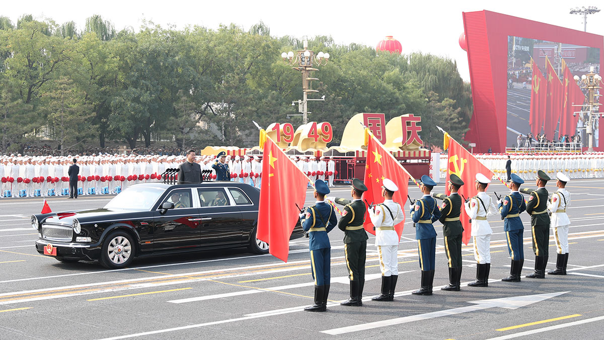 習(xí)近平驅(qū)車行進(jìn)至黨旗、國旗、軍旗前，向旗幟行注目禮