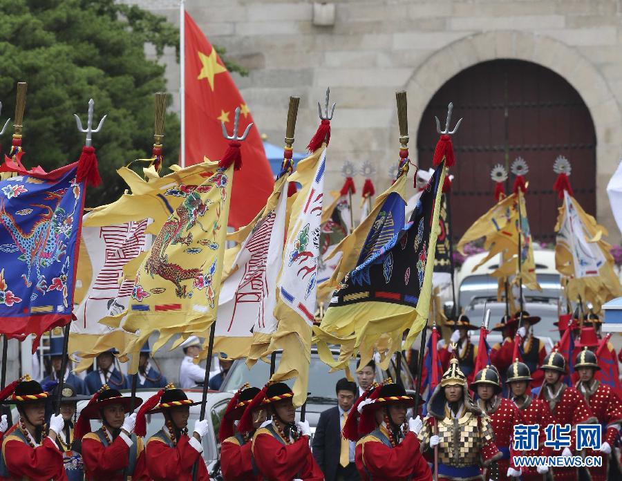 7月3日，韓國(guó)總統(tǒng)樸槿惠在青瓦臺(tái)總統(tǒng)府舉行隆重儀式，歡迎中國(guó)國(guó)家主席習(xí)近平對(duì)韓國(guó)進(jìn)行國(guó)事訪問(wèn)。這是習(xí)近平的車隊(duì)在身著民族服裝的韓國(guó)禮儀隊(duì)伍引導(dǎo)下駛?cè)肭嗤吲_(tái)。新華社記者丁林?jǐn)z  